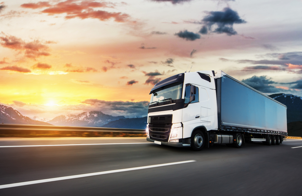 European truck vehicle on motorway with dramatic sunset light. Cargo transportation and supply theme.