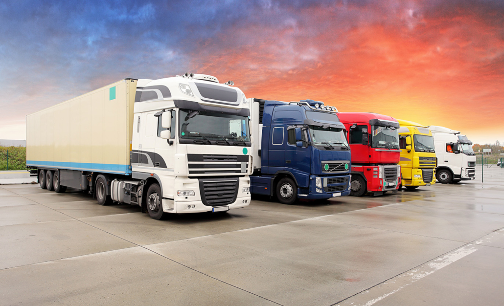 A lineup of colorful commercial trucks parked side by side, representing heavy-duty vehicles supported by Baldwin filters from A&C Engineering.