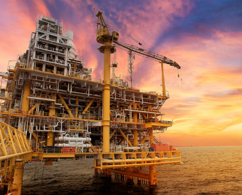 Pneumatic Solutions for Marine and Offshore Applications Offshore oil and gas platform with cranes and processing equipment at sunset.